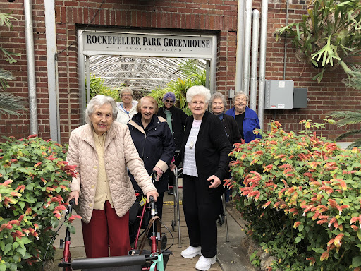 A joyful group of seniors enjoying their time outdoors at a care facility.