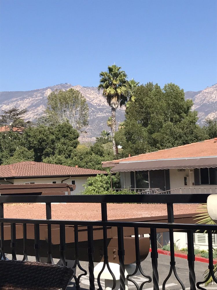 A scenic view of houses with mountains and trees in the background.