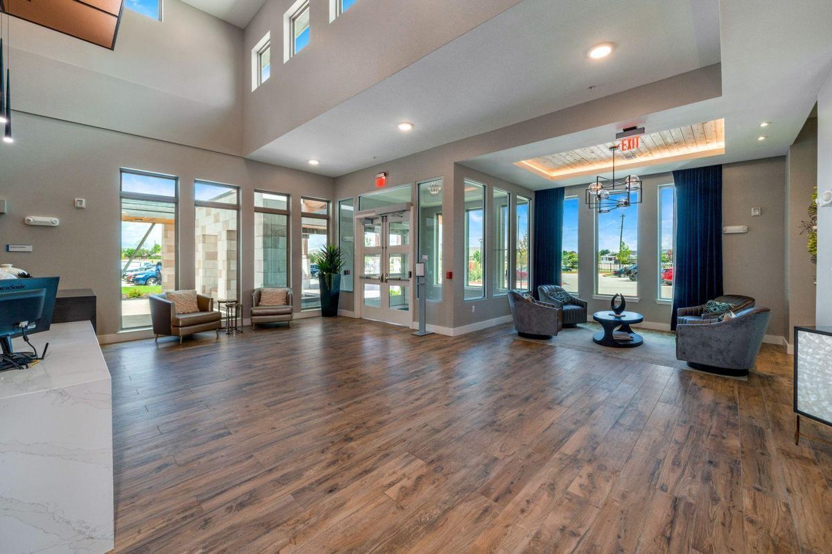 A spacious, modern lobby with wood flooring and comfortable seating areas.