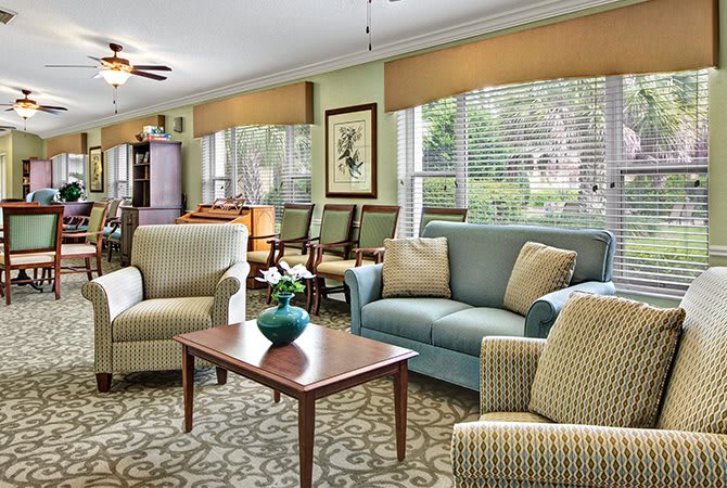 A cozy living room with comfortable seating and natural light from large windows.