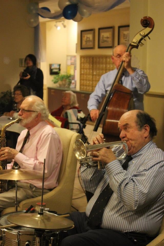 A jazz band performing live with musicians playing trumpet, saxophone, and double bass.