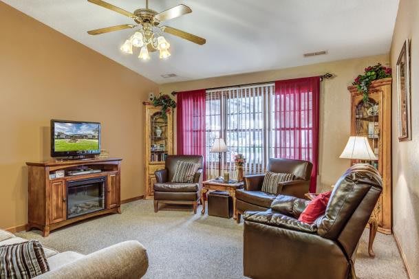 A cozy living room with comfortable seating, a TV, and warm lighting.