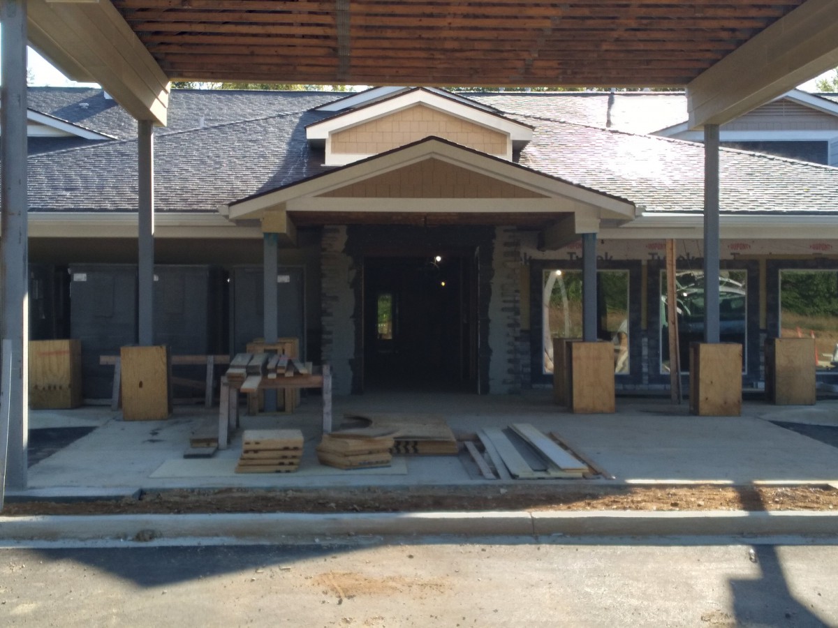 Under-construction building entrance with visible materials and scaffolding.