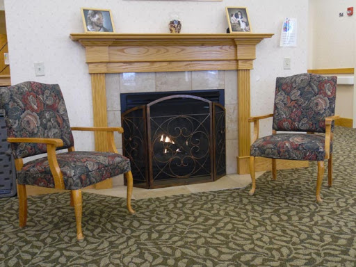 A cozy living room featuring a fireplace and two upholstered chairs.