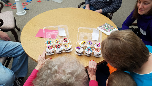 A delightful spread of colorful cupcakes enjoyed by a small group at a social gathering.
