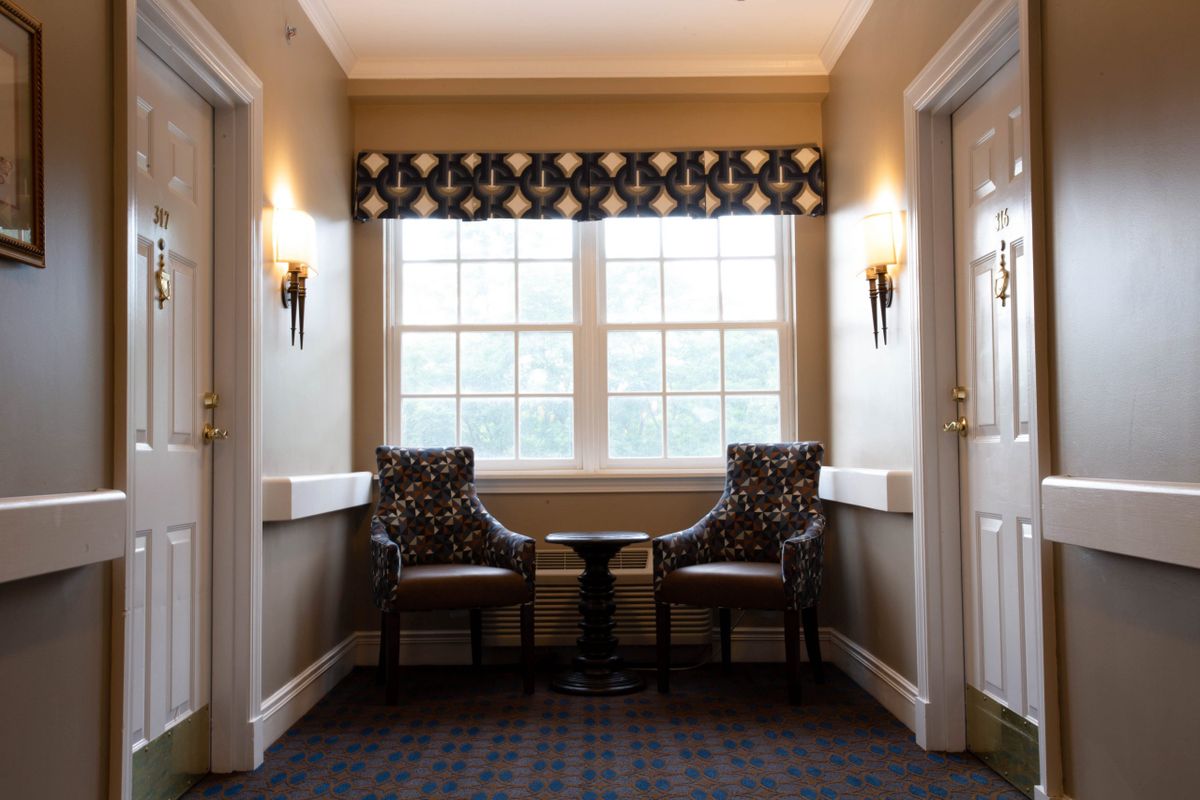 A cozy seating area with two chairs and a small table by the window.