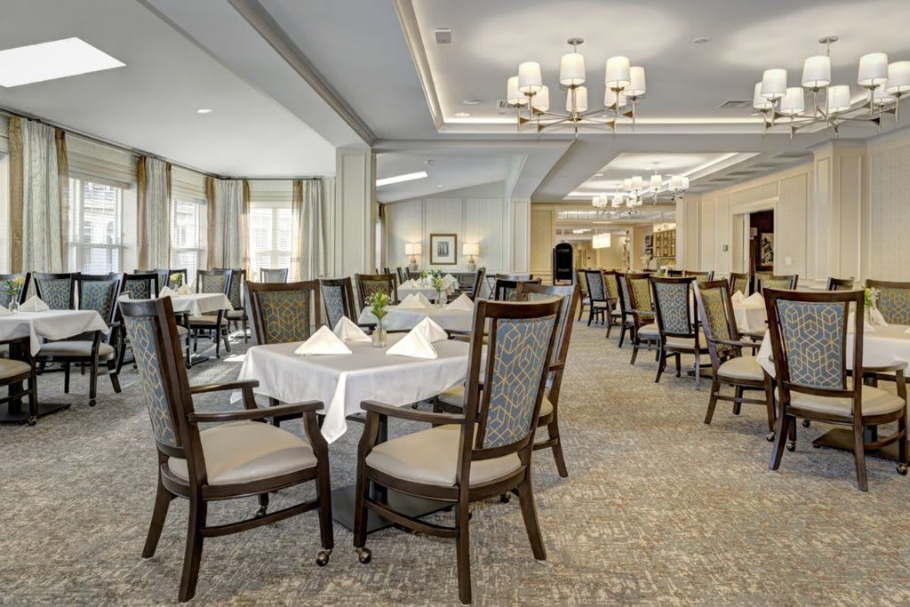 A spacious and elegantly decorated dining room with neatly arranged tables and chairs.