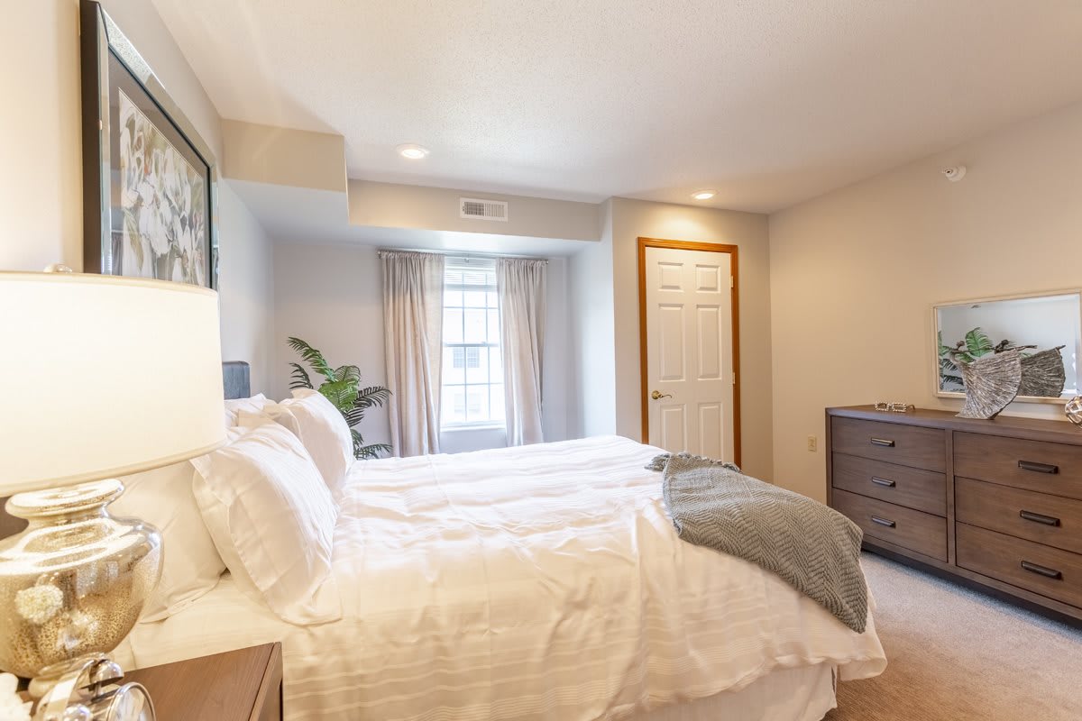 A cozy, modern bedroom with a neatly made bed and bright natural light.