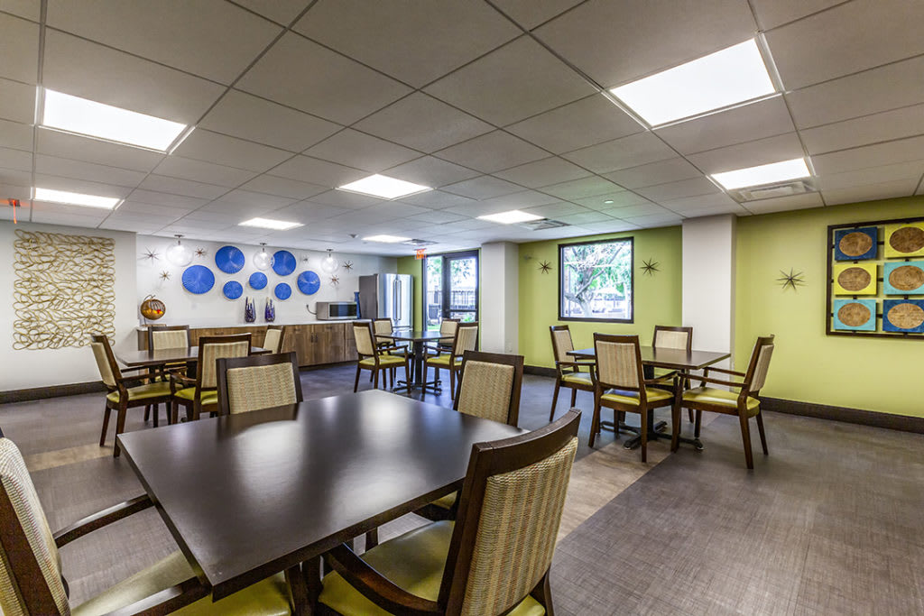 A modern dining area with neatly arranged tables and chairs, featuring stylish decor and ample lighting.