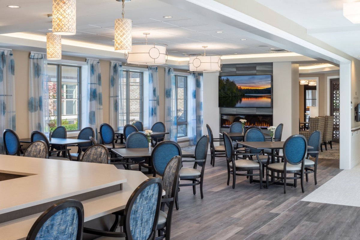 A modern dining area with blue chairs and elegant lighting.
