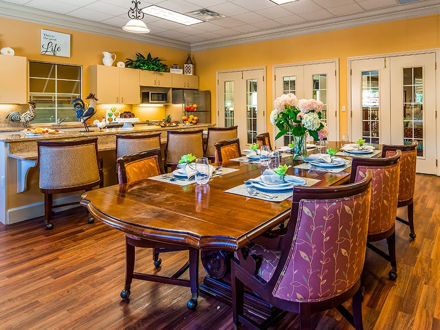 A well-decorated dining room with a set table and an adjoining kitchen area.