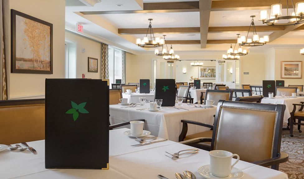A well-lit restaurant dining room with neatly set tables, chairs, and menus.