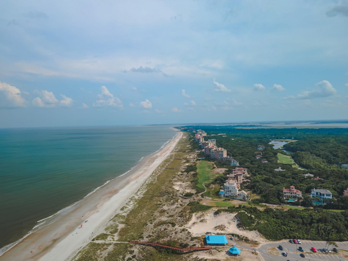 Aerial view of a coastal resort lined with buildings along the beach.