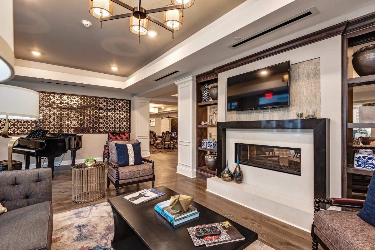 A modern living room featuring a cozy seating area, fireplace, and television, complemented by stylish interior decor.