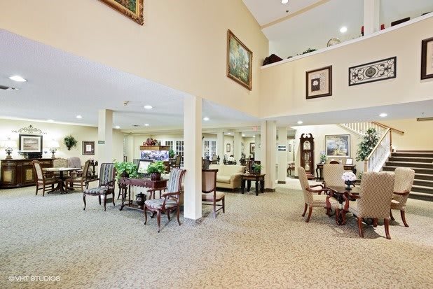 A spacious interior with elegant dining tables and chairs, adorned with decorative elements and soft lighting.