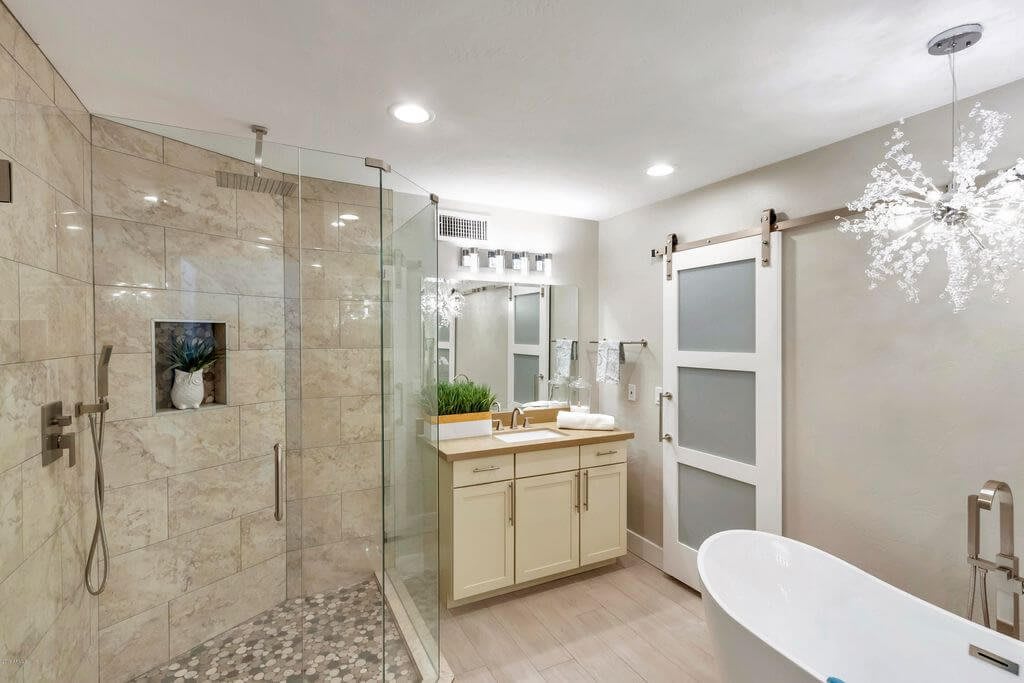 A modern and stylish bathroom with a glass-enclosed shower, freestanding bathtub, and sleek vanity.