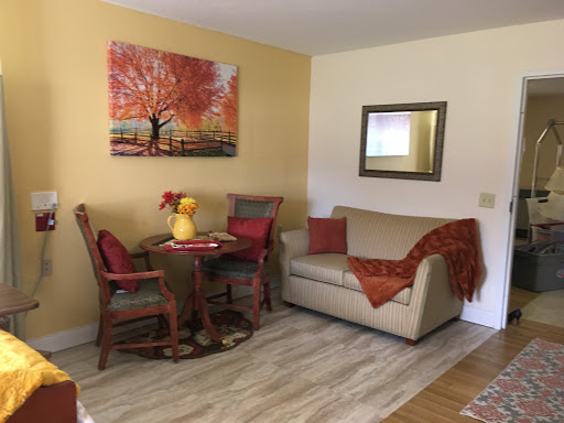 A cozy living space featuring a small dining area and a comfortable sofa, enhanced by warm colors and decorative artwork.