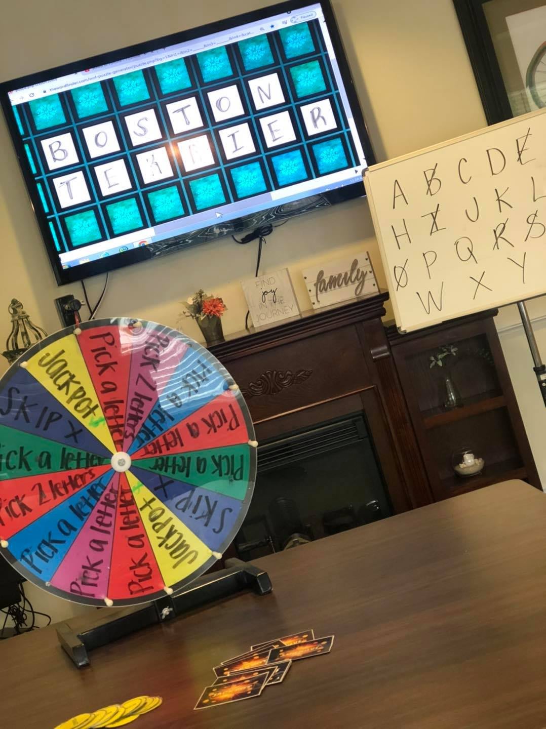 Game setup with a spinning wheel and a puzzle board on the screen.