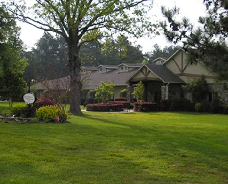 A charming house with a well-maintained garden and lush green lawn.