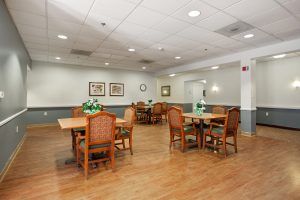 A cozy dining area with several tables and chairs arranged neatly, under bright ceiling lights.