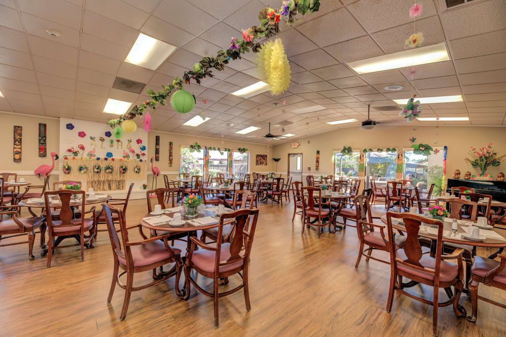 An empty dining room with tables set and decorated ceilings.