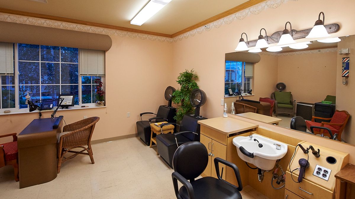 A cozy salon interior with styling chairs, mirrors, and a washing sink.