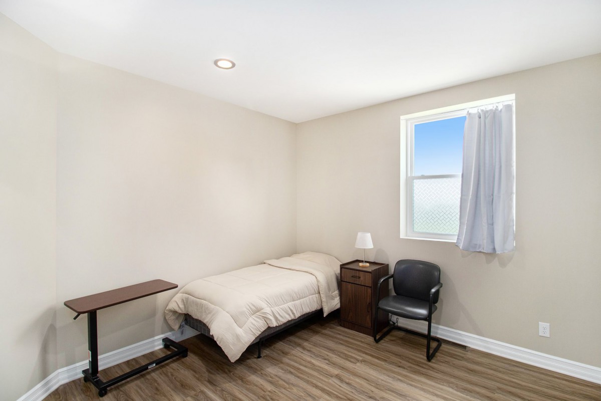 A minimalist bedroom with a single bed and basic furnishings.