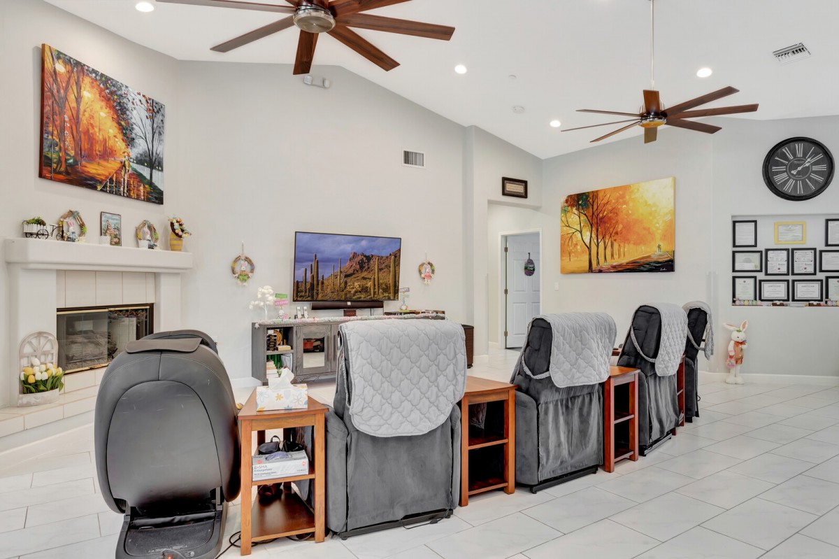 A modern nail salon interior featuring massage chairs and contemporary artwork.