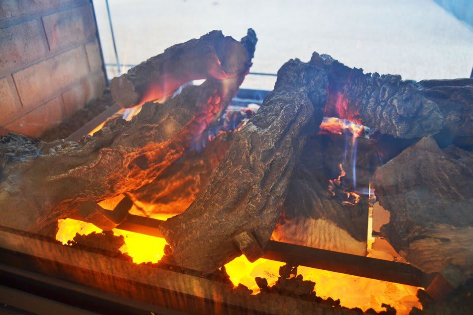 A cozy indoor fireplace with glowing logs and flickering flames.