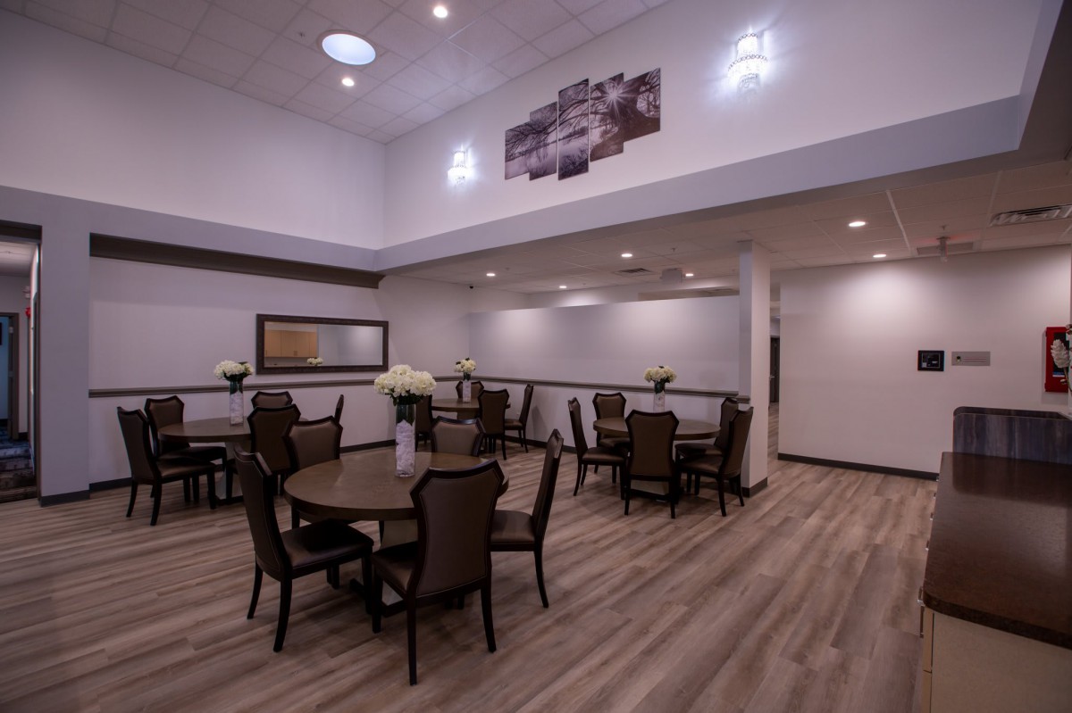 A modern dining area with multiple tables and chairs, featuring elegant lighting and decor.