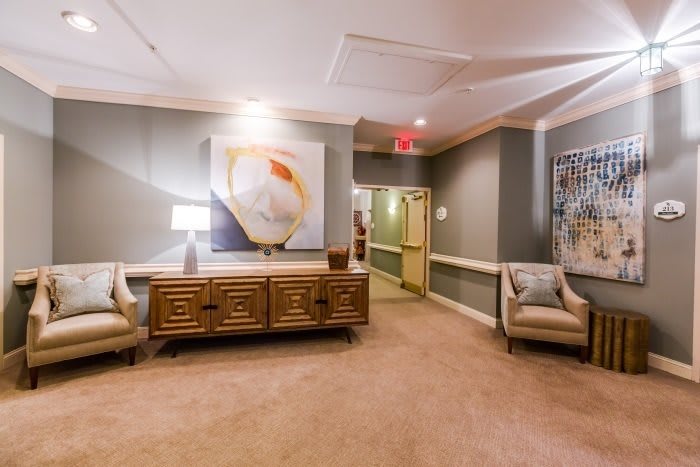 A well-decorated lobby area featuring comfortable seating, artwork on the wall, and warm lighting.