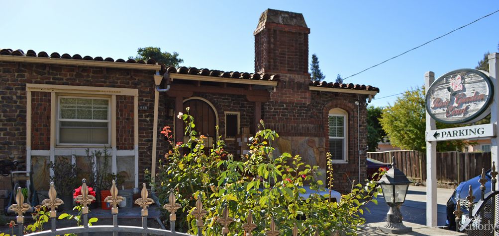 A charming brick house with a chimney and garden.