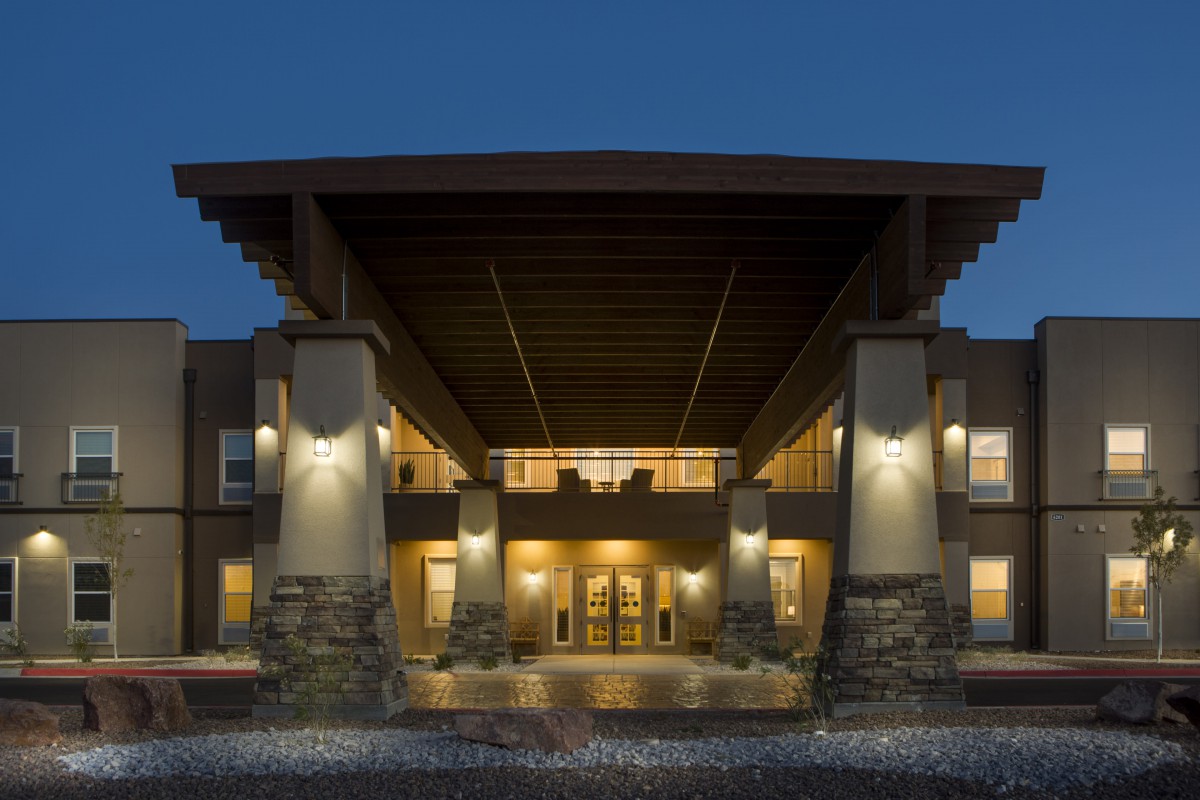 Illuminated building entrance at night with modern architectural design.