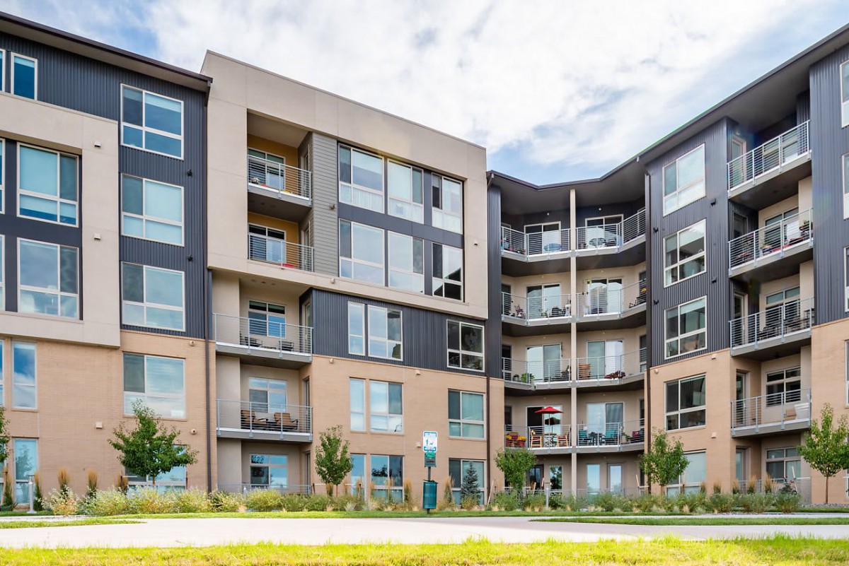 A modern apartment building with multiple balconies and large windows.