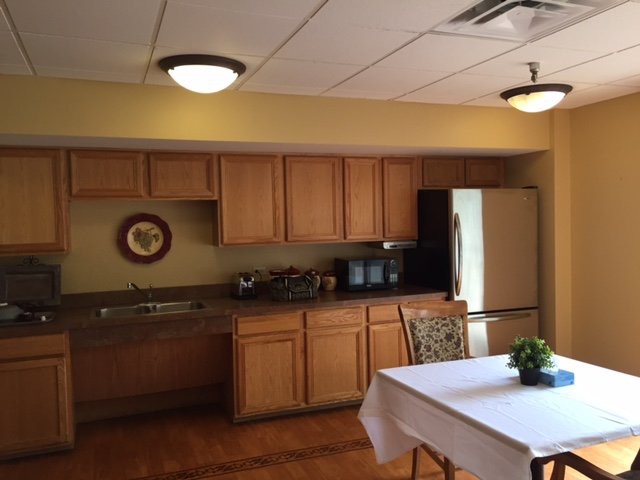 A cozy kitchen and dining area with wooden cabinets and a small table.