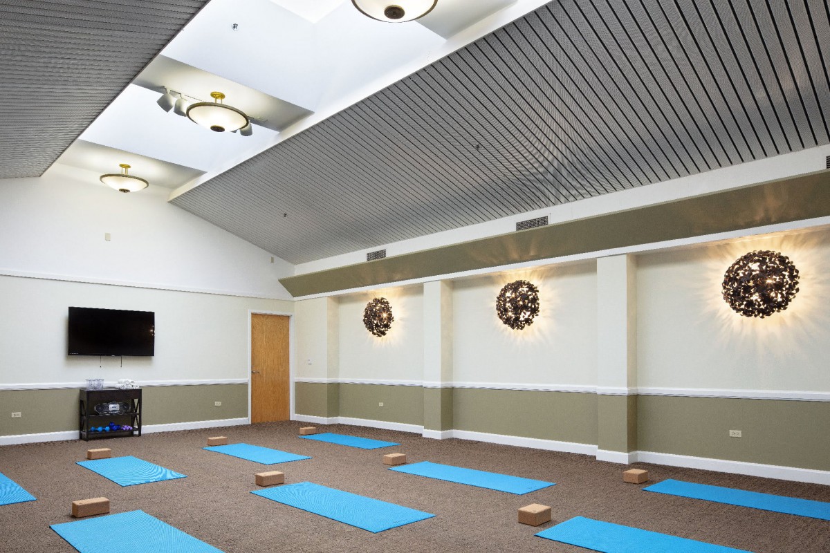 A serene yoga studio with neatly arranged blue mats and wooden blocks, ready for a calming session.