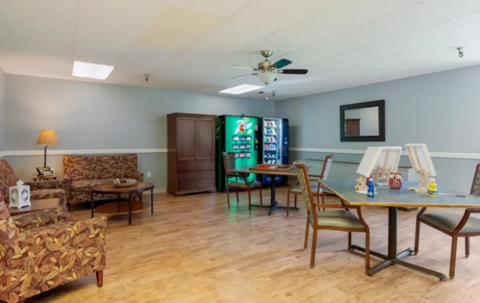 A waiting area with seating, tables, and vending machines.