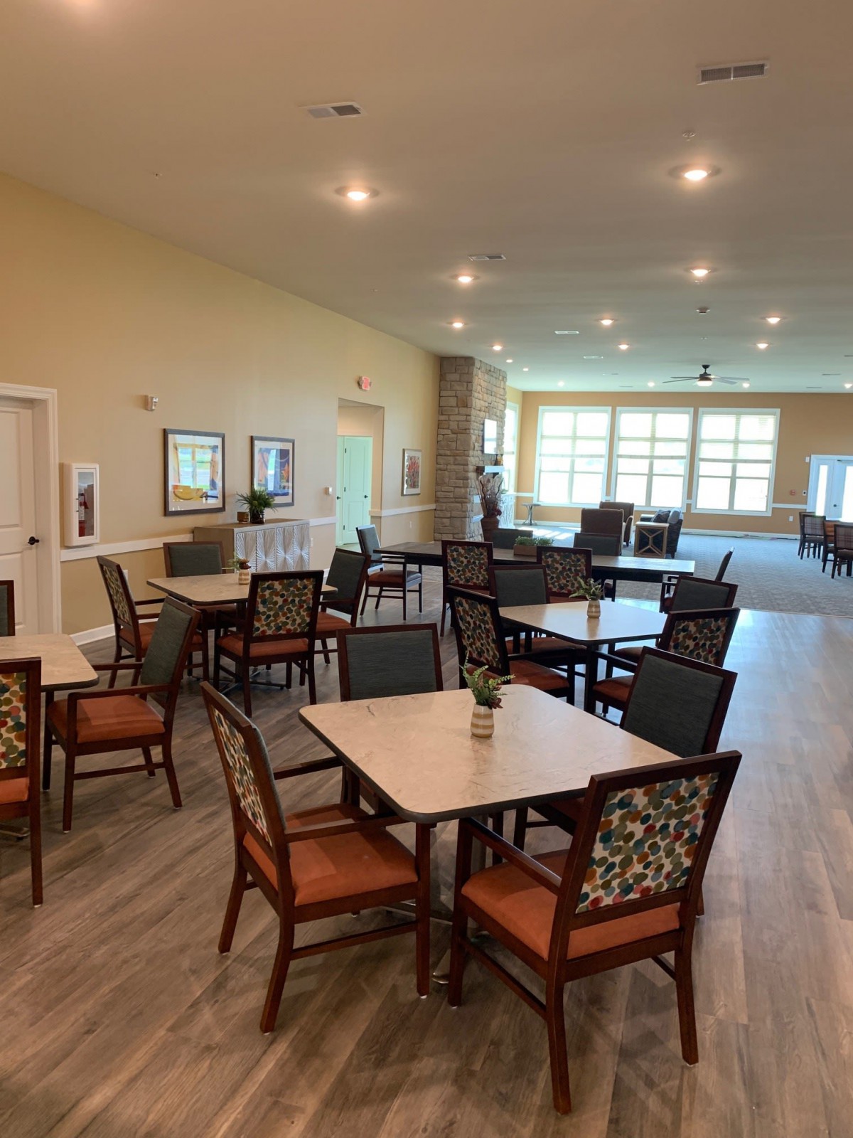 A spacious and well-lit dining area with multiple tables and chairs arranged neatly.