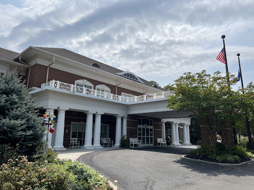 A picturesque view of a hotel entrance featuring classical architecture and a U.S. flag.