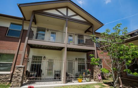 A two-story house with balconies and a garden.