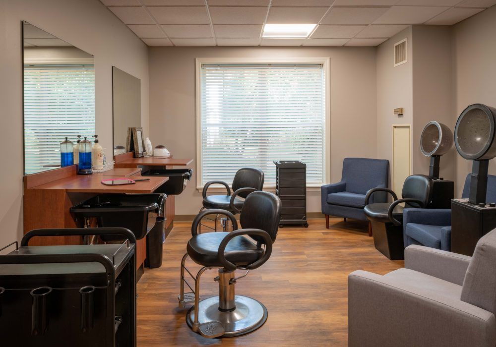 A well-lit hair salon interior featuring styling chairs, mirrors, and a waiting area with comfortable seating.