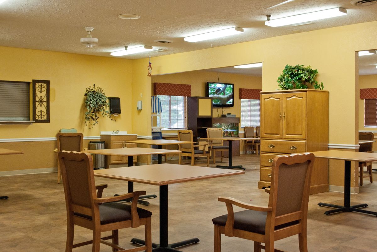 Cozy dining area with wooden furniture and a television on the wall.