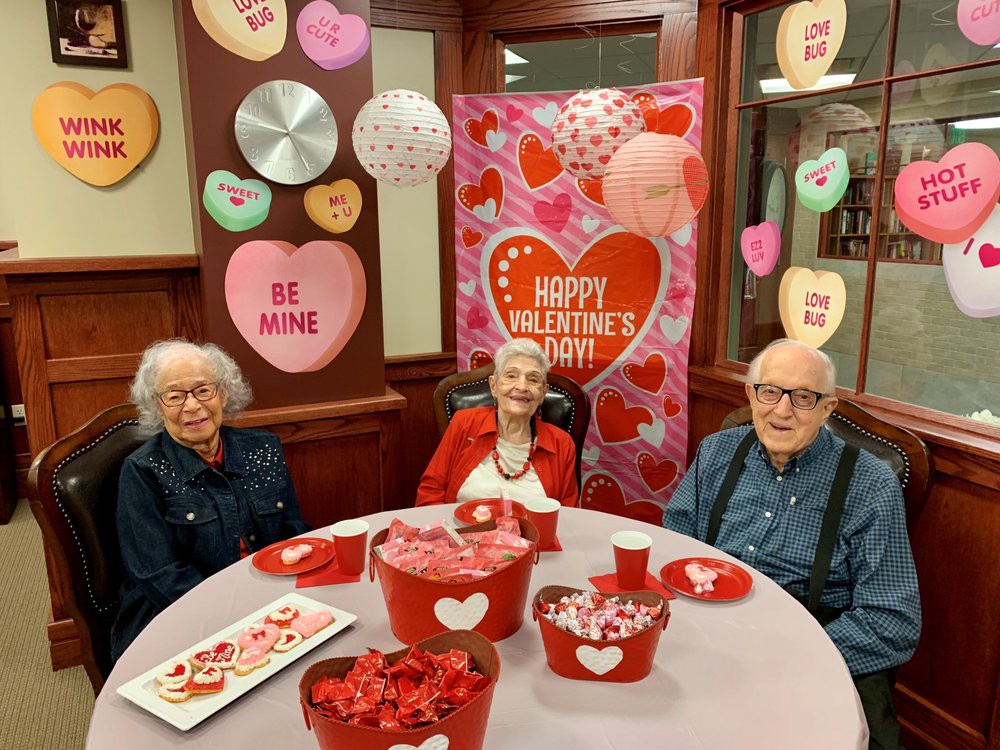 Seniors celebrating Valentine's Day with festive decorations and heart-themed treats.