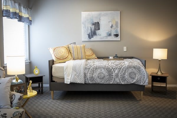 A neatly arranged bedroom with modern decor and warm lighting.