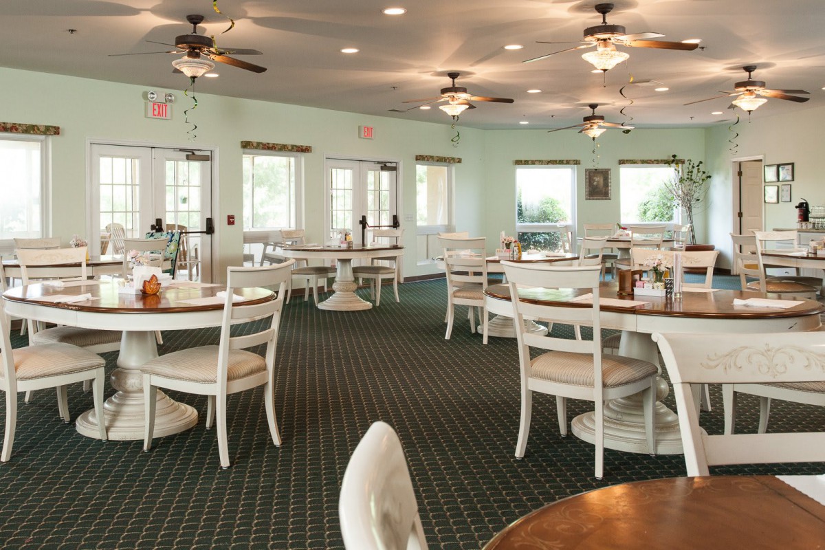 An empty restaurant dining area with neatly arranged tables and chairs.