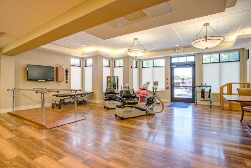 A bright and spacious rehabilitation gym featuring various exercise equipment, designed for promoting fitness and wellness.