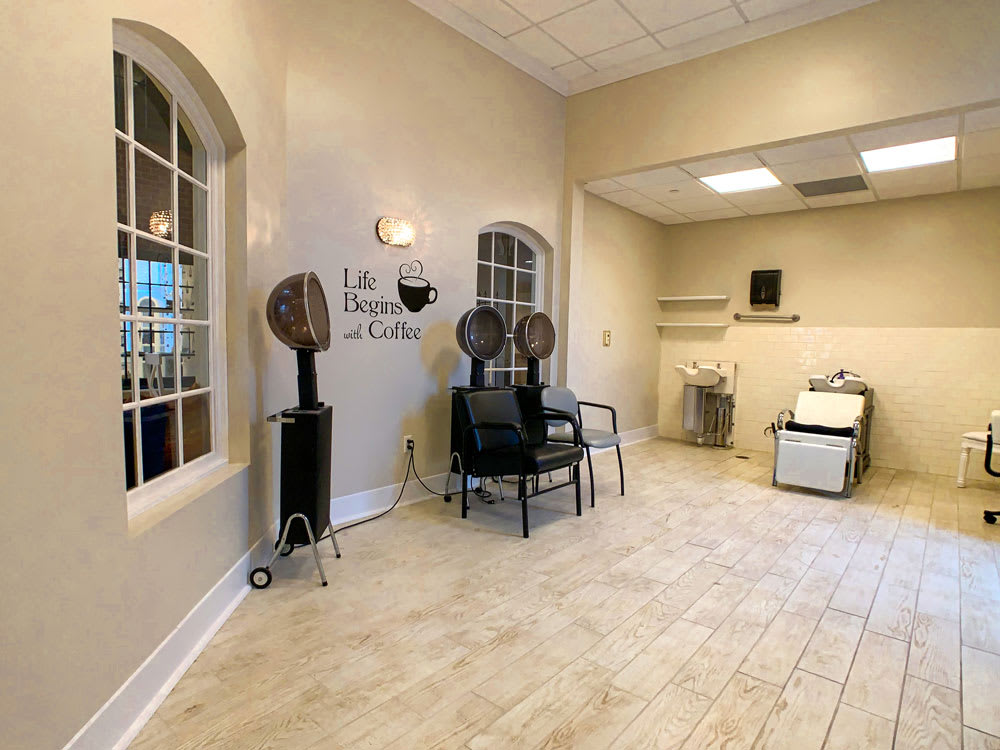 A modern salon interior with a waiting area and hair drying stations.