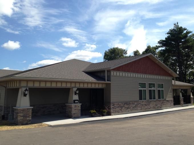 A suburban house with a sloped roof under a blue sky.