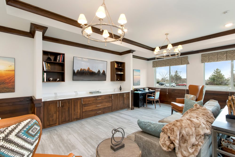 A modern living room with elegant lighting, wooden cabinets, and a large window.