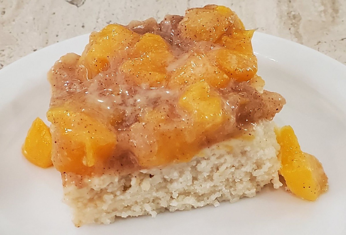 A slice of cake with peach fruit topping.